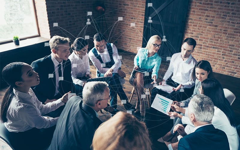 Employees sitting on chairs in a circle engaged in conversation and planning
